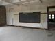 A classroom with its blackboard still in place but ceiling and exterior walls stripped.