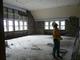 A corner lab with exterior sheetrock removed, exposing the original ceiling and windows. The windows and original ceiling heights will be restored.