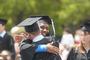 Graduates hug after receiving their diplomas.<em><span style=font-size:9pt;>&nbsp;Credit: Bob MacDonnell</span></em>