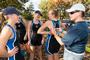 Chatting with the rowers from Boat A, women's rowing coach Eva Kovach helps Caity Sprague '13 pin the boat number to her unisuit.