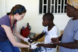  EMT Shannon Brady '14 works with a child during her spring break trip to Haiti last year. 
