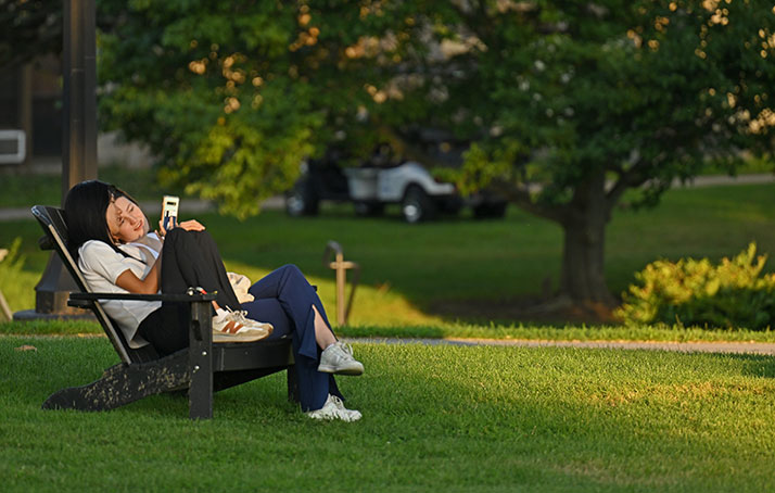 Student reading on the green