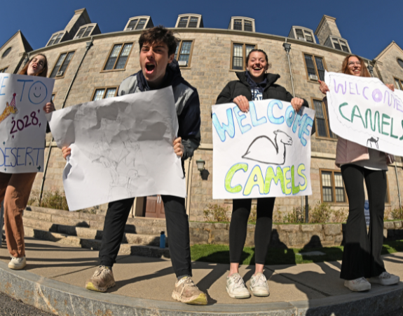 Students welcoming admitted students to campus with signs.