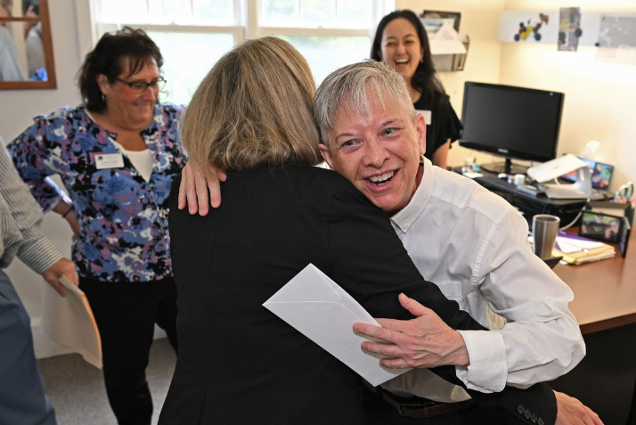President Andrea Chapdelaine surprises Kip Wilson with the Camel Community Award in their office.