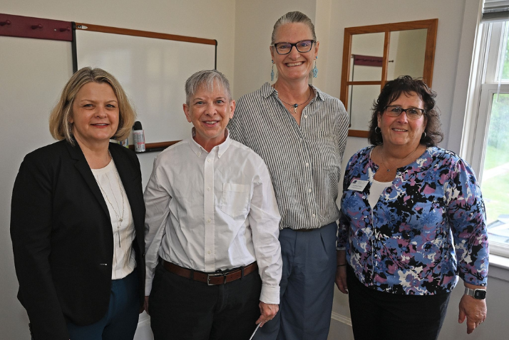 President Andrea Chapdelaine, Kip Wilson, Merrill Collins, and Lynne Crider pose for a photo after awarding Wilson's Camel Community Award.