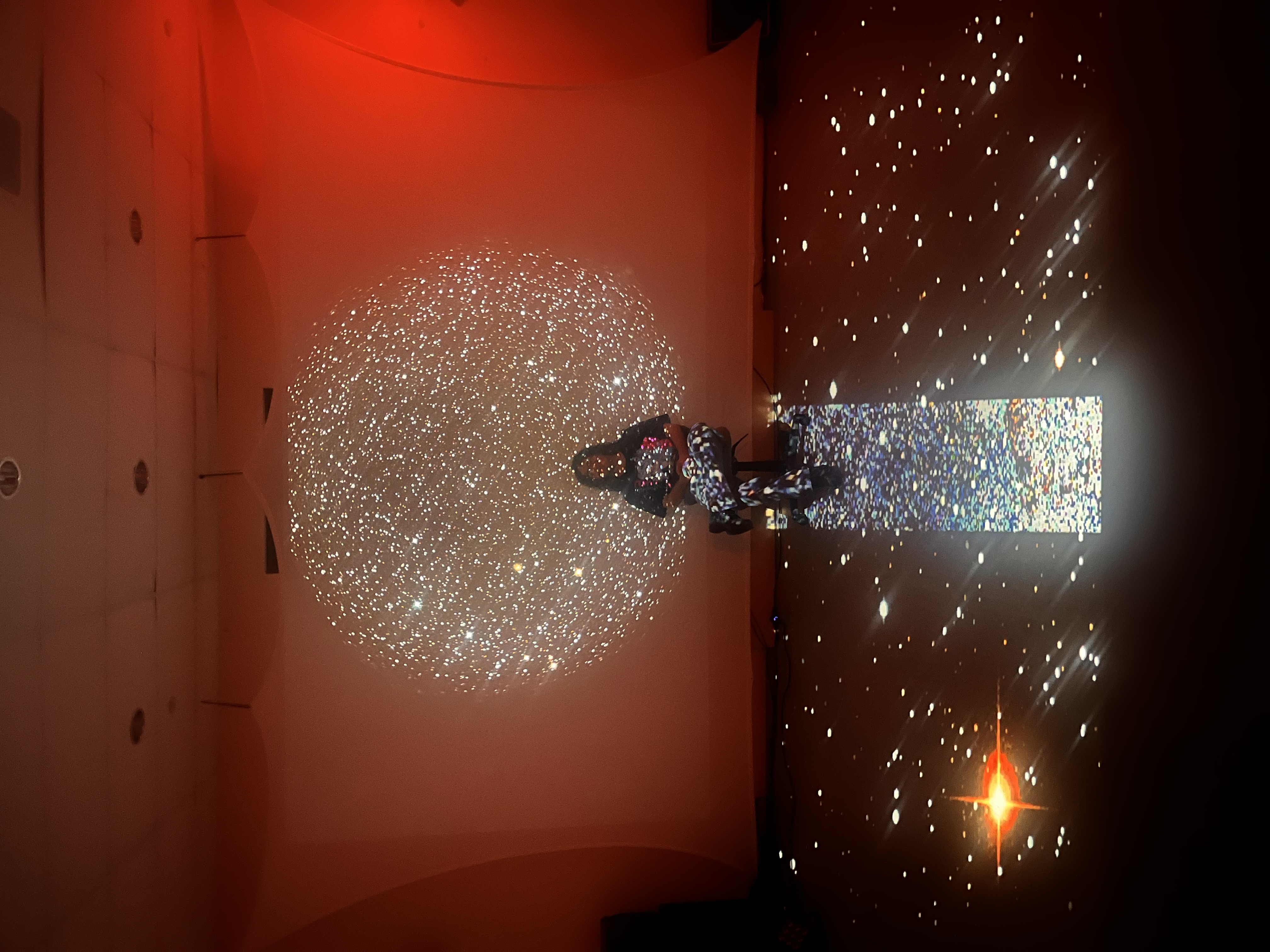 A figure seated with a light projection on them.