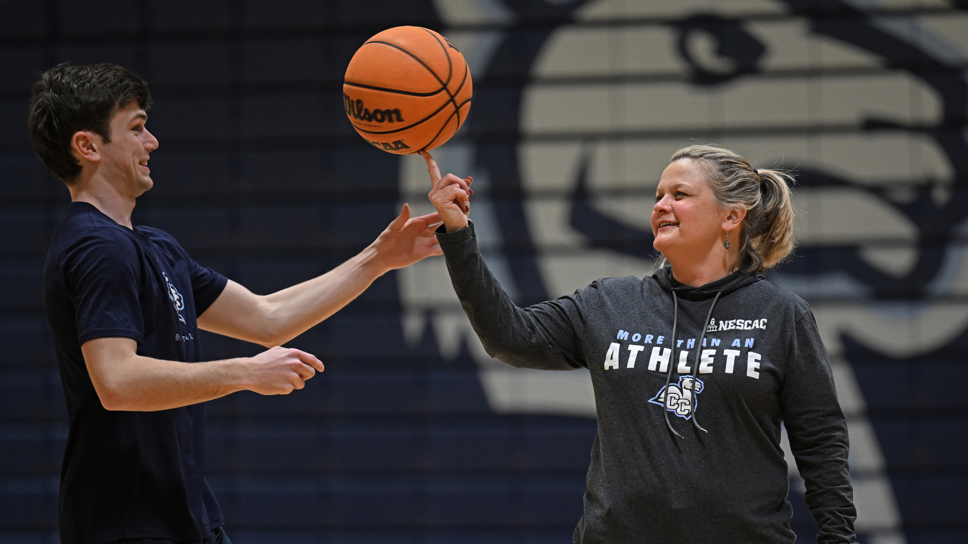 President Chapdelaine spinning a basketball with a student.