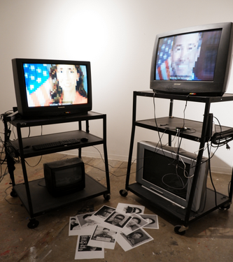 A photo of two TVs showing smiling faces with the American flag behind them.