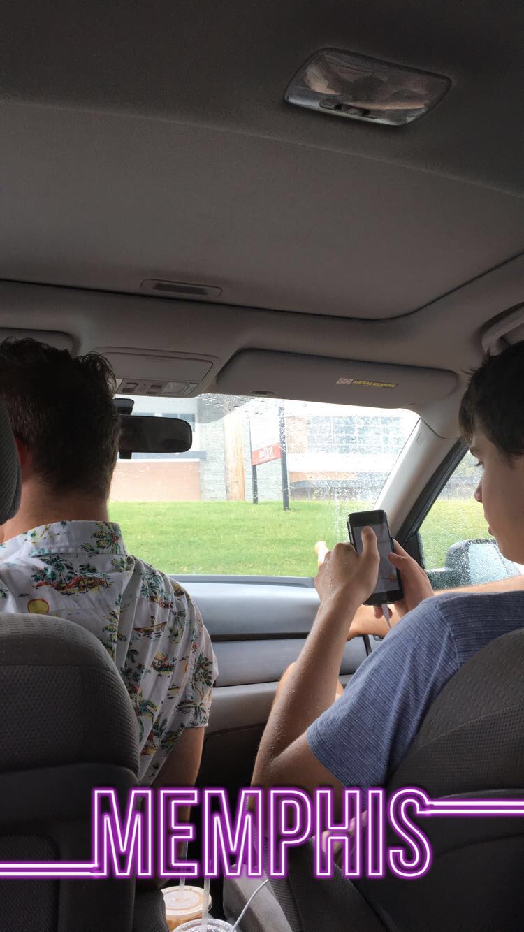Samuel navigates on his phone while Mark drives the car through Memphis.