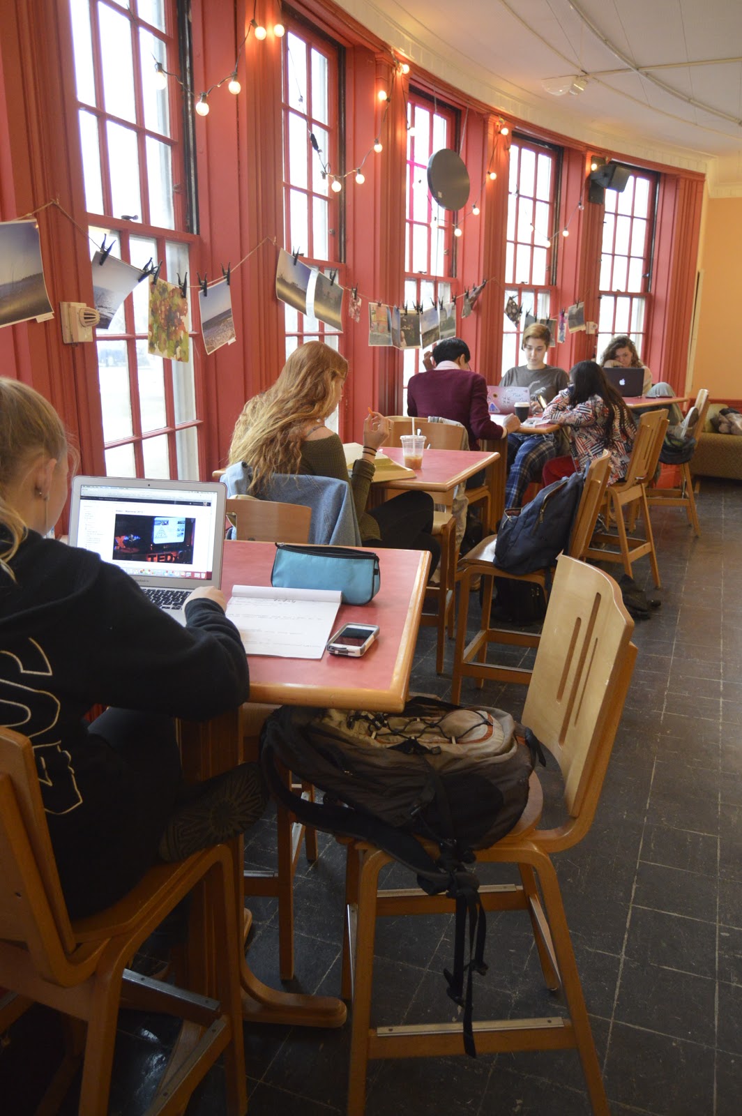Students studying in front of the bright windows in the Coffee Closet