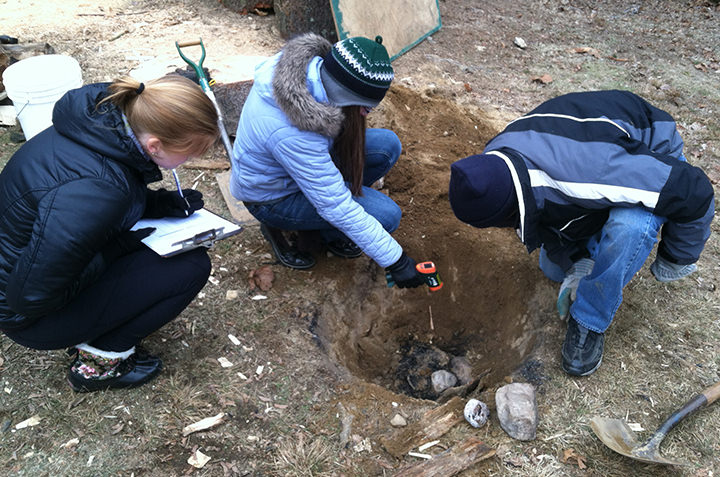Students in Anthropology 396 (Experimental Archaeology) measure the temperature and record fracture patterns on stone cobbles in an experiment addressing stone fracture rates in Indigenous North American earth ovens.