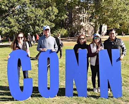 Parents pose with CONN letters at Fall Weekend