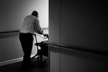 Elderly man pushing a wheelchair
