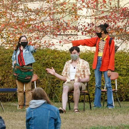 Students in masks performing outdoor theater
