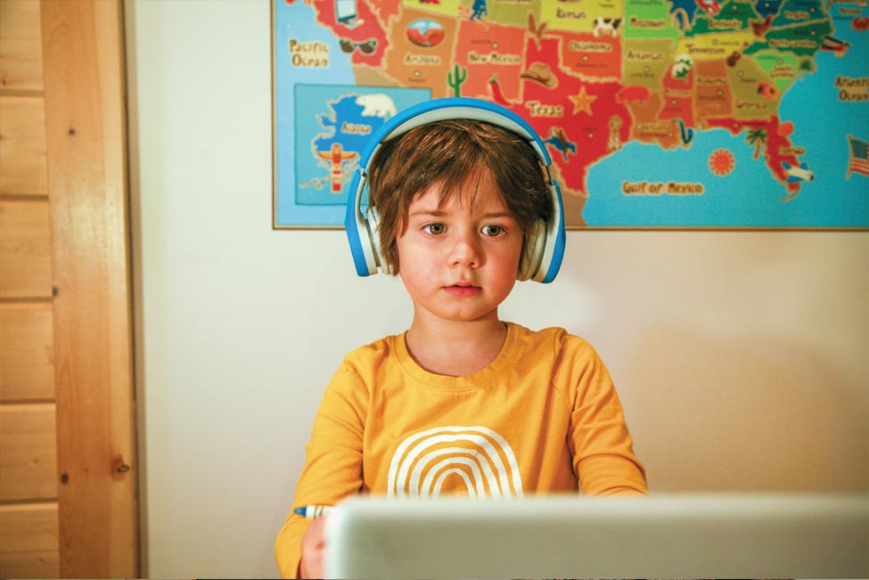 Image of child at computer wearing headphones