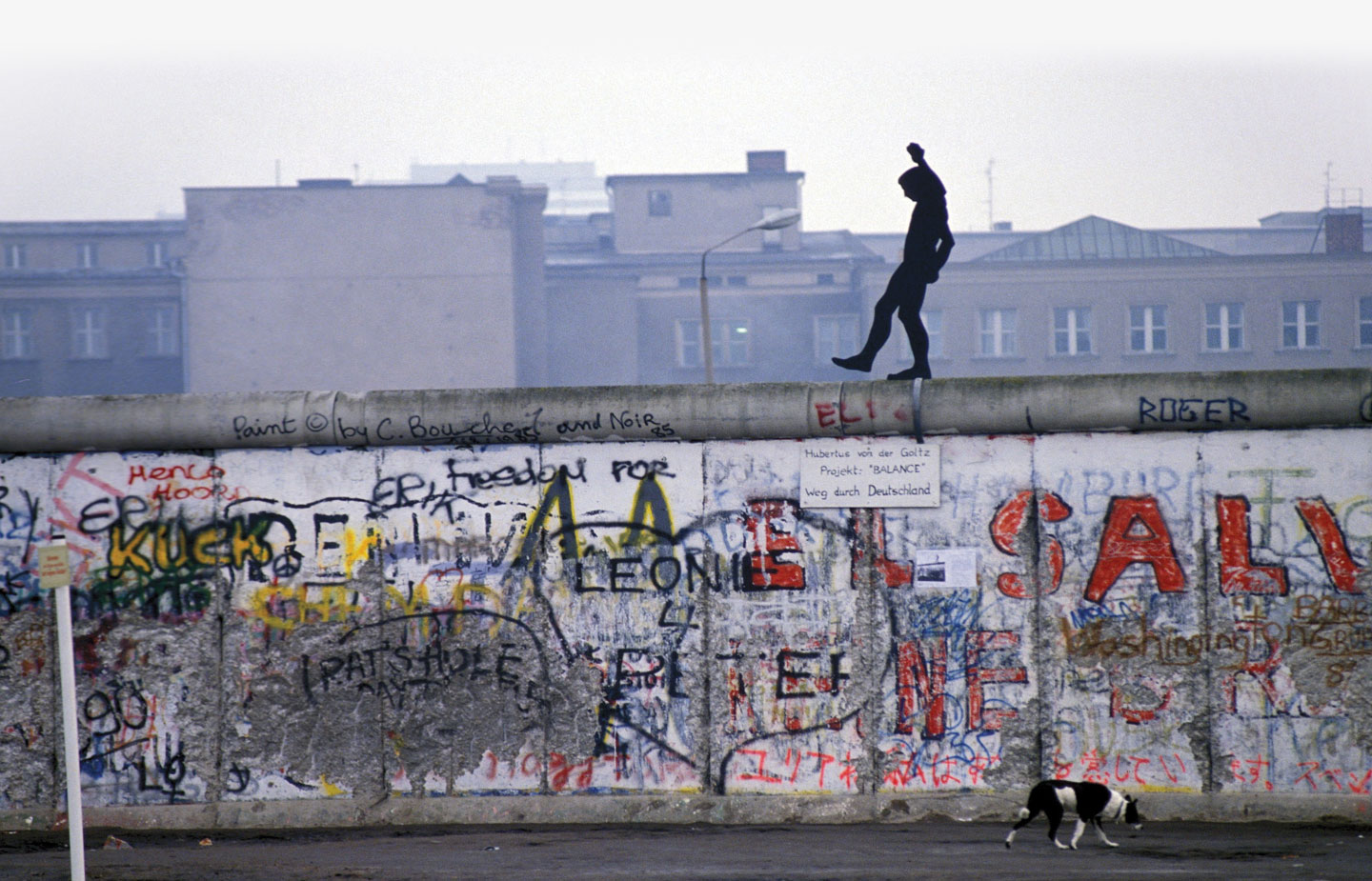 Image of man walking on the wall in Berlin in the early 1990s.