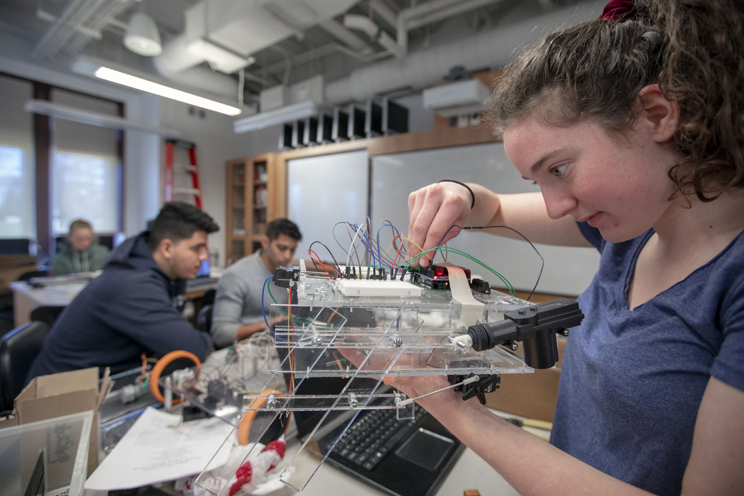Image of female student working on a circuit board