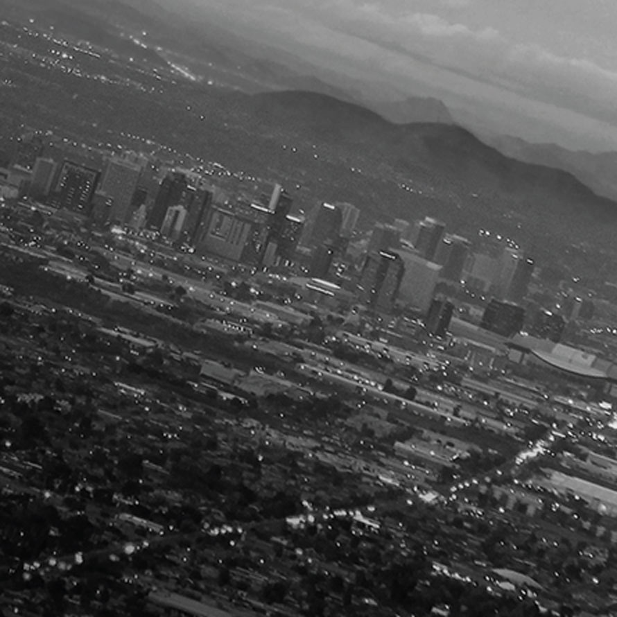 Black and white aerial scene of a city in the mountains