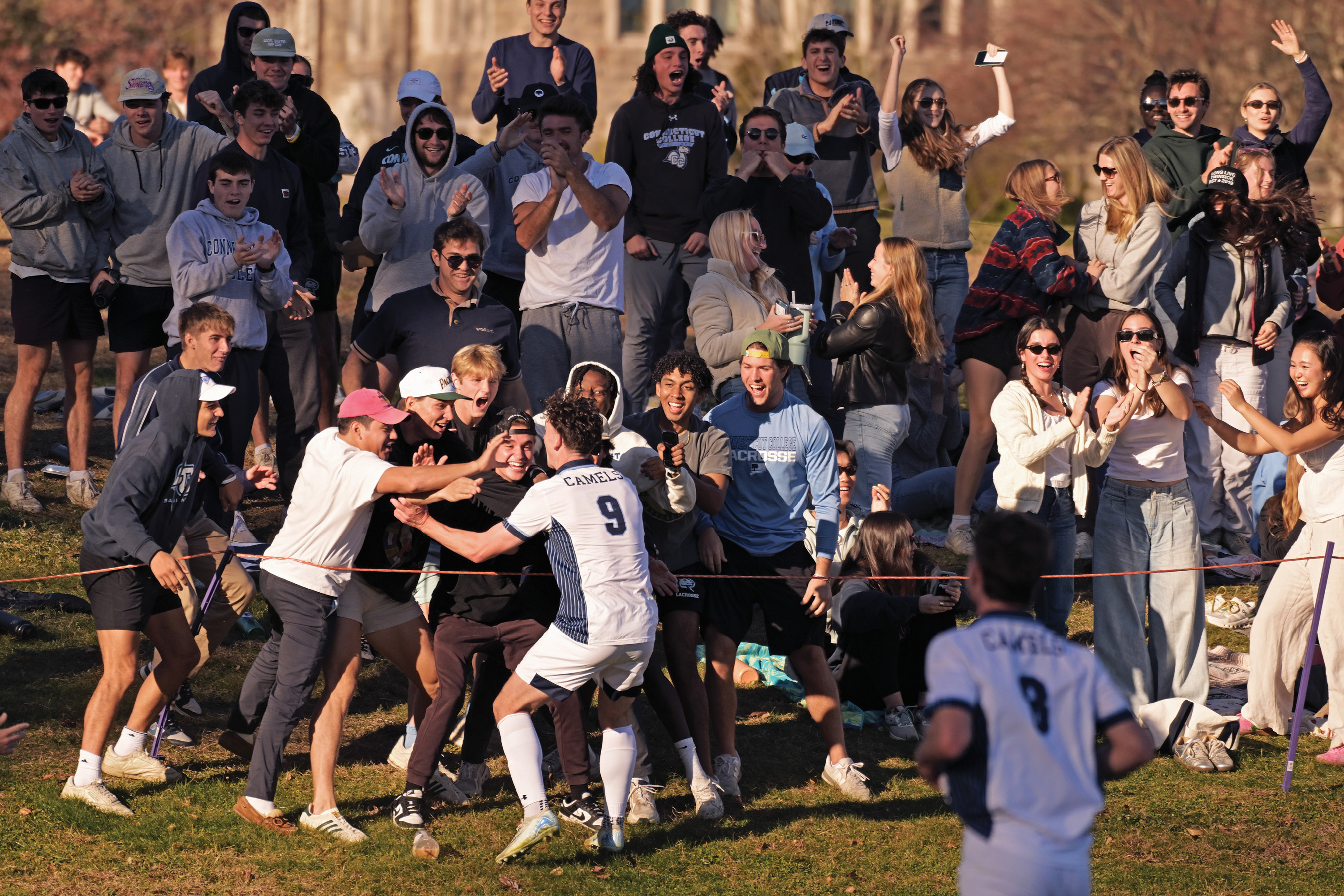 A crowd cheers on the men's soccer team on the Green at Conn.