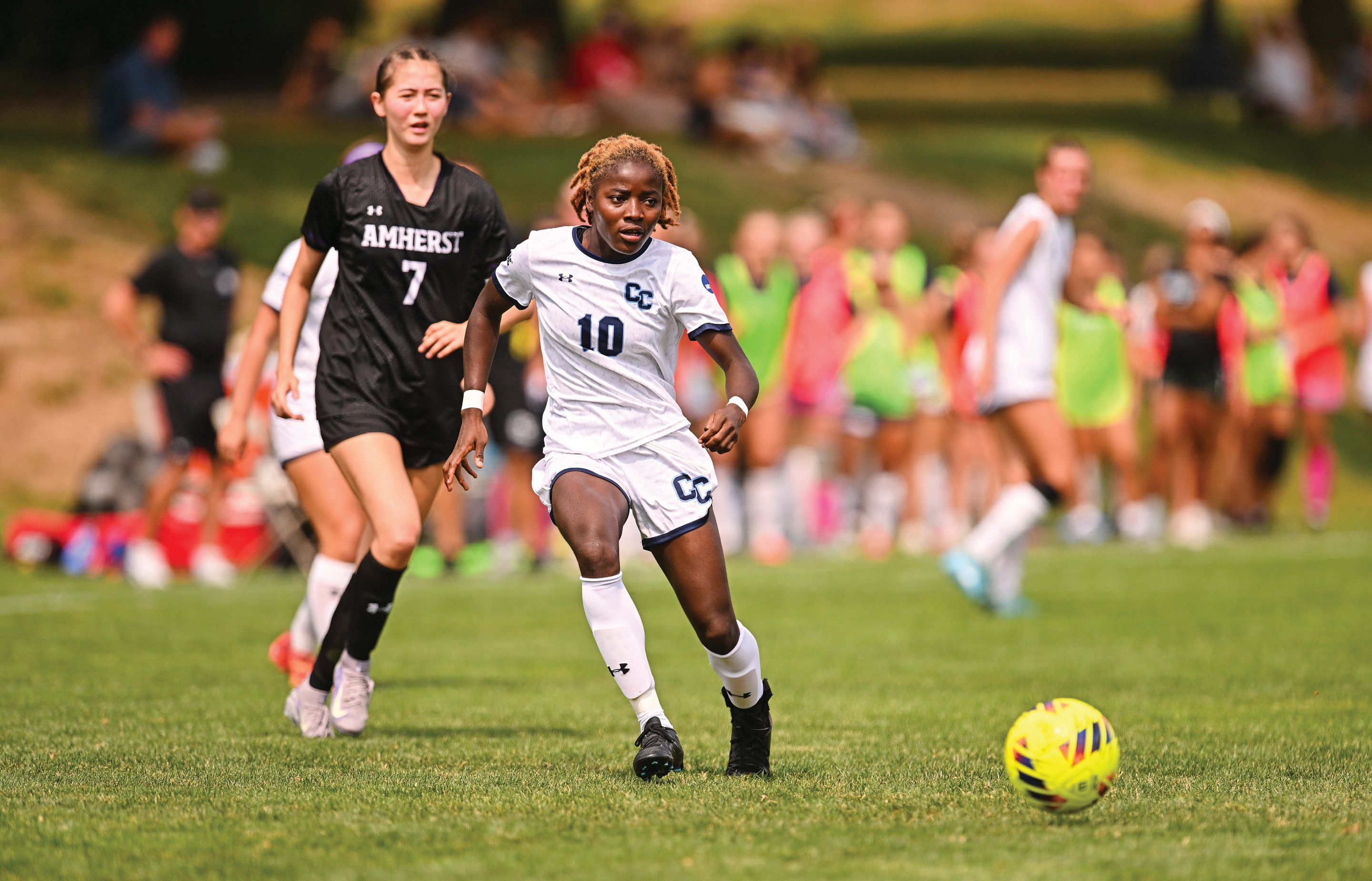 Blessing Kieh '28 kicking a ball on the soccer field.