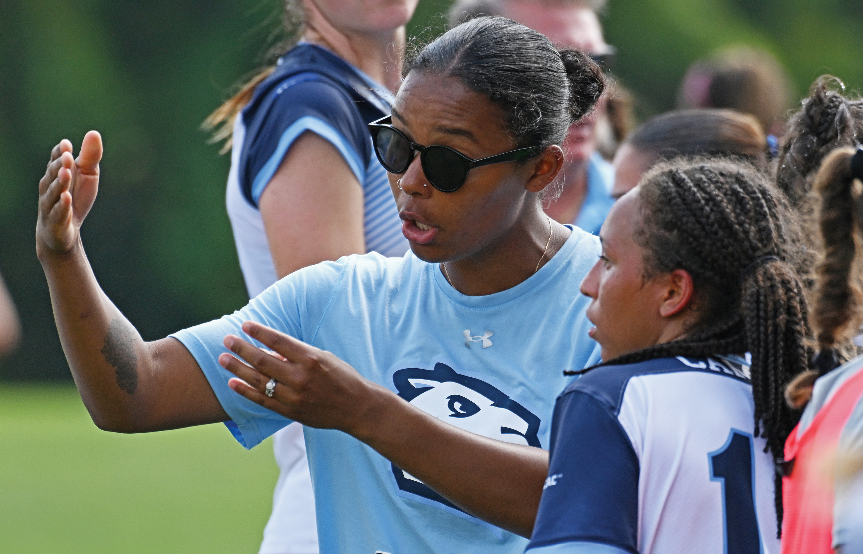 Women's soccer Mia Hernandez '20 coaches a player on the sidelines.