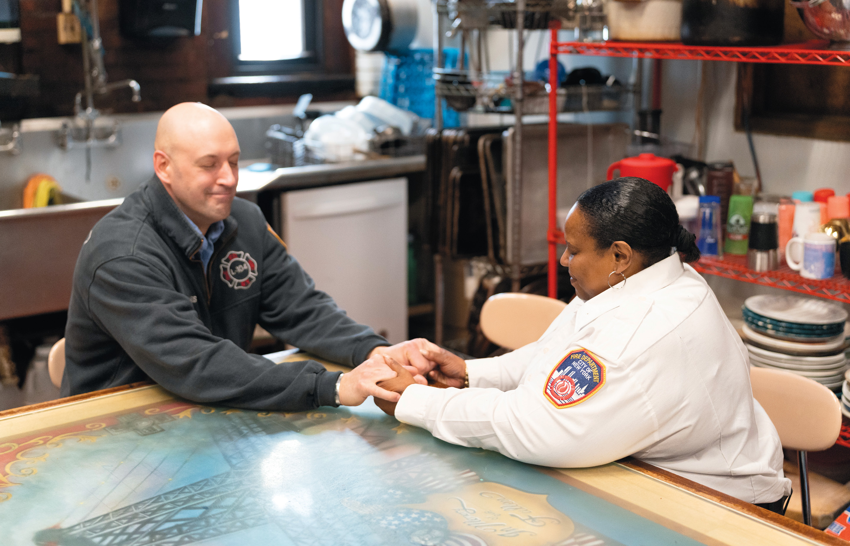 The Rev. Pamela Holmes ’89, far right, prays with another fire fighter