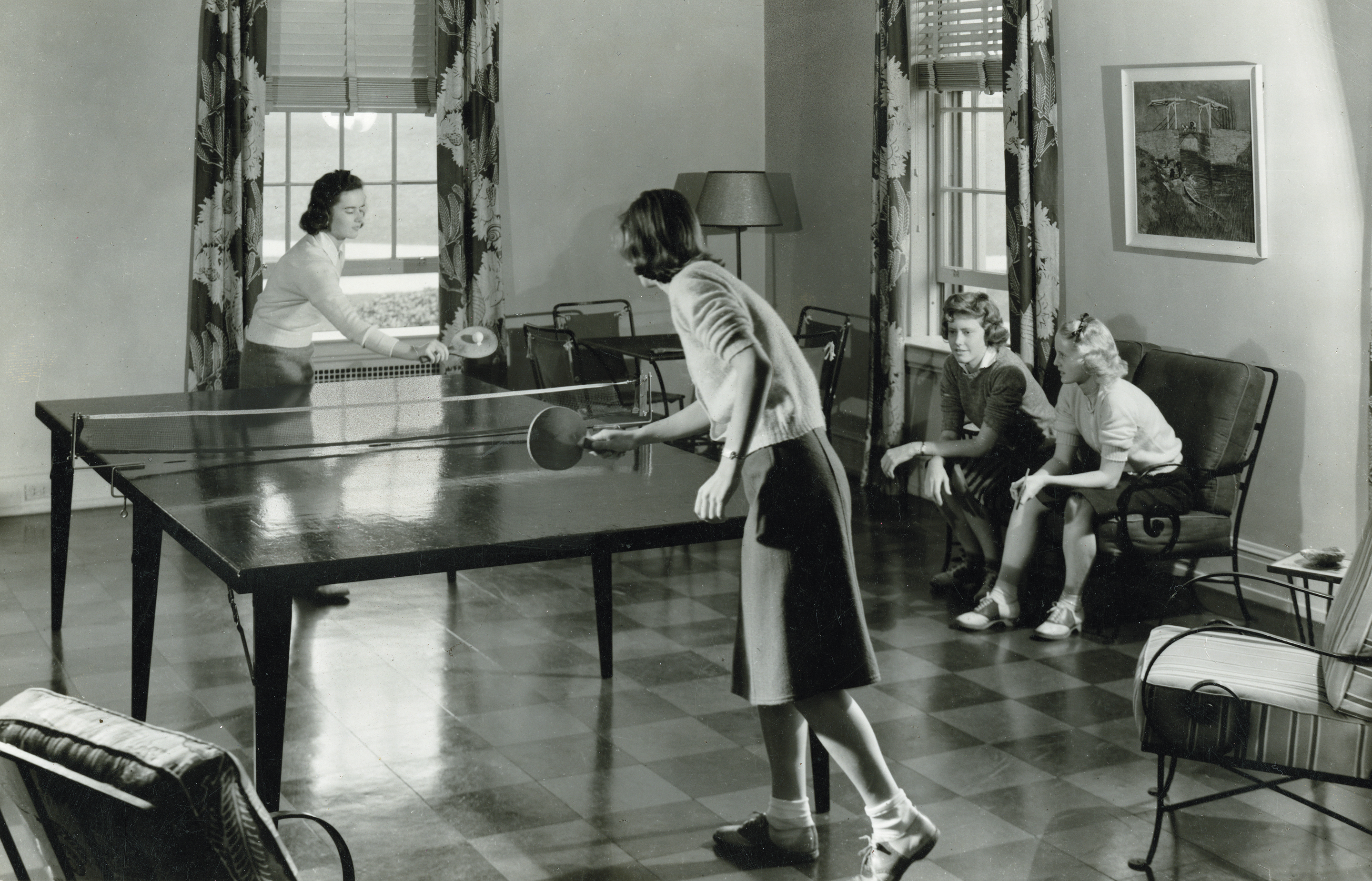 Vintage black and white image of students playing ping pong in a dorm