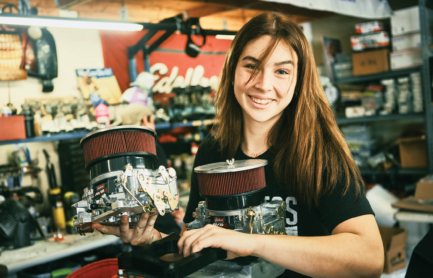 Riley Schlick-Trask ’27 holding engine parts in a garage