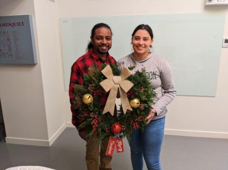 A couple displays the wreath they made at the Wreath-Making Workshop