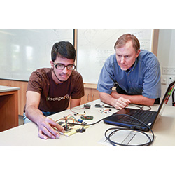 Robot research: Mohammed Khan '17, left, is working with Computer Science professor Gary Parker, right, on an independent research project to build a robot with the artificial intelligence to learn to drive without colliding with objects in its path. 