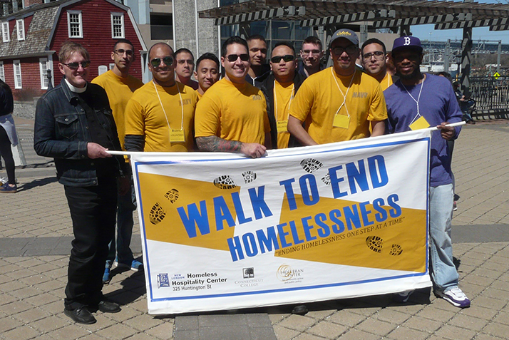 Volunteers from the United States Navy pose with the Walk to End Homelessness sign. 