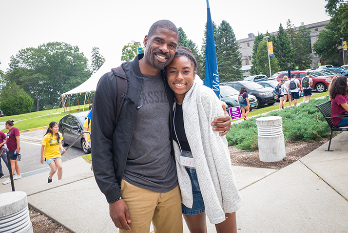 A father and daughter pose together on campus. 