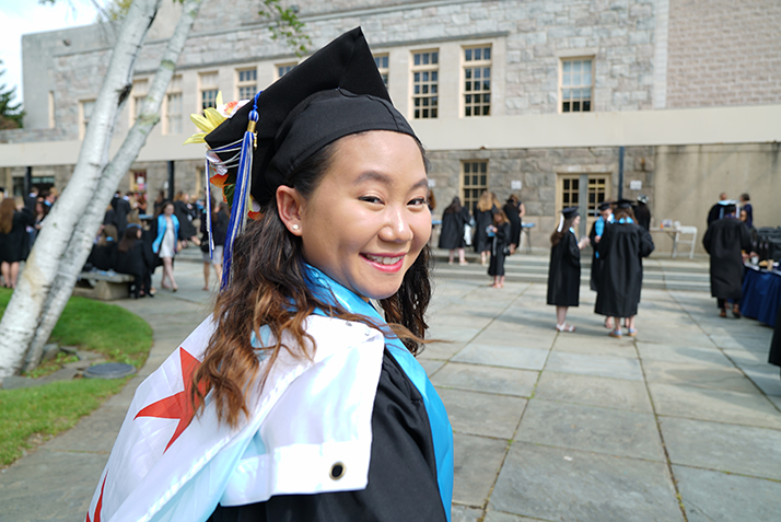A graduate smiles over her shoulder before Commencement begins