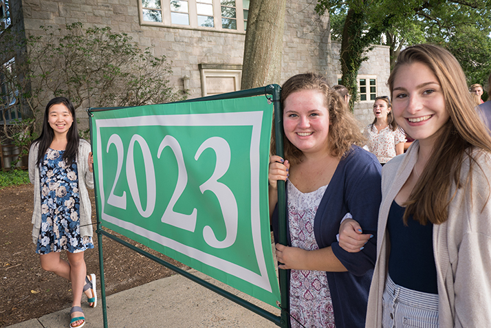 New students pose with the Class of 2023 banner