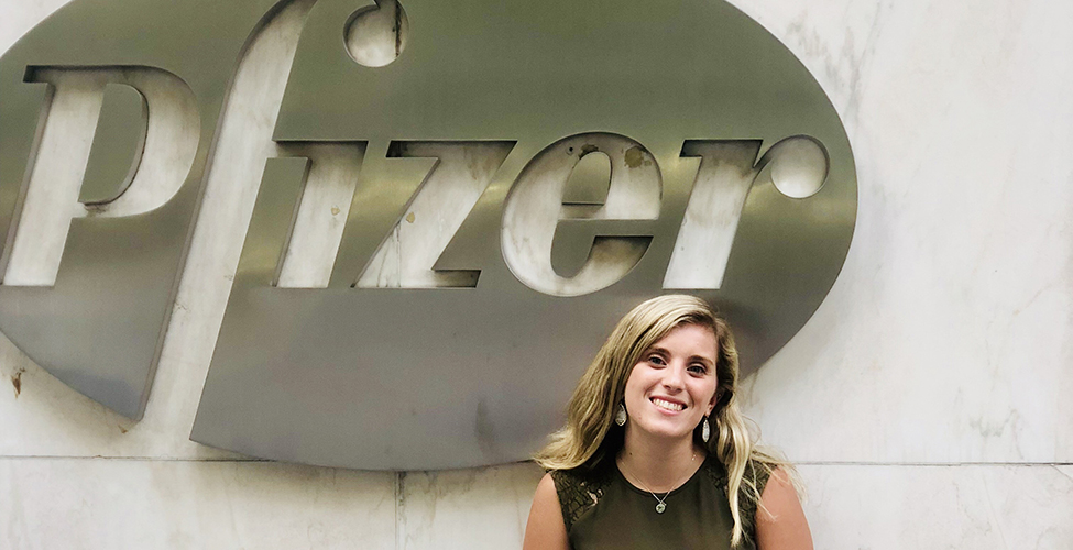 Victoria Azoulay in front of the Pfizer logo.