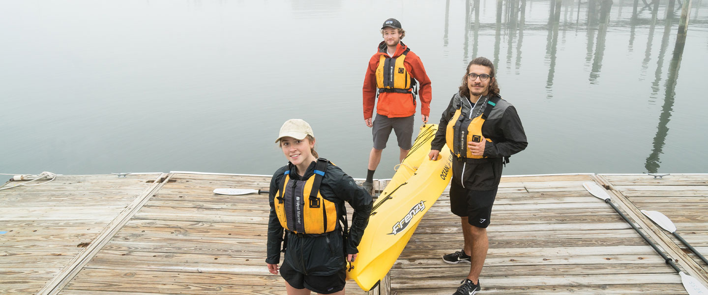 Students carrying yellow kayak