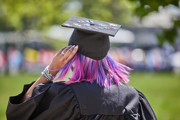 A graduate adjusts her cap.