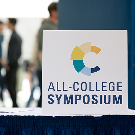 A sign for the All-College Symposium