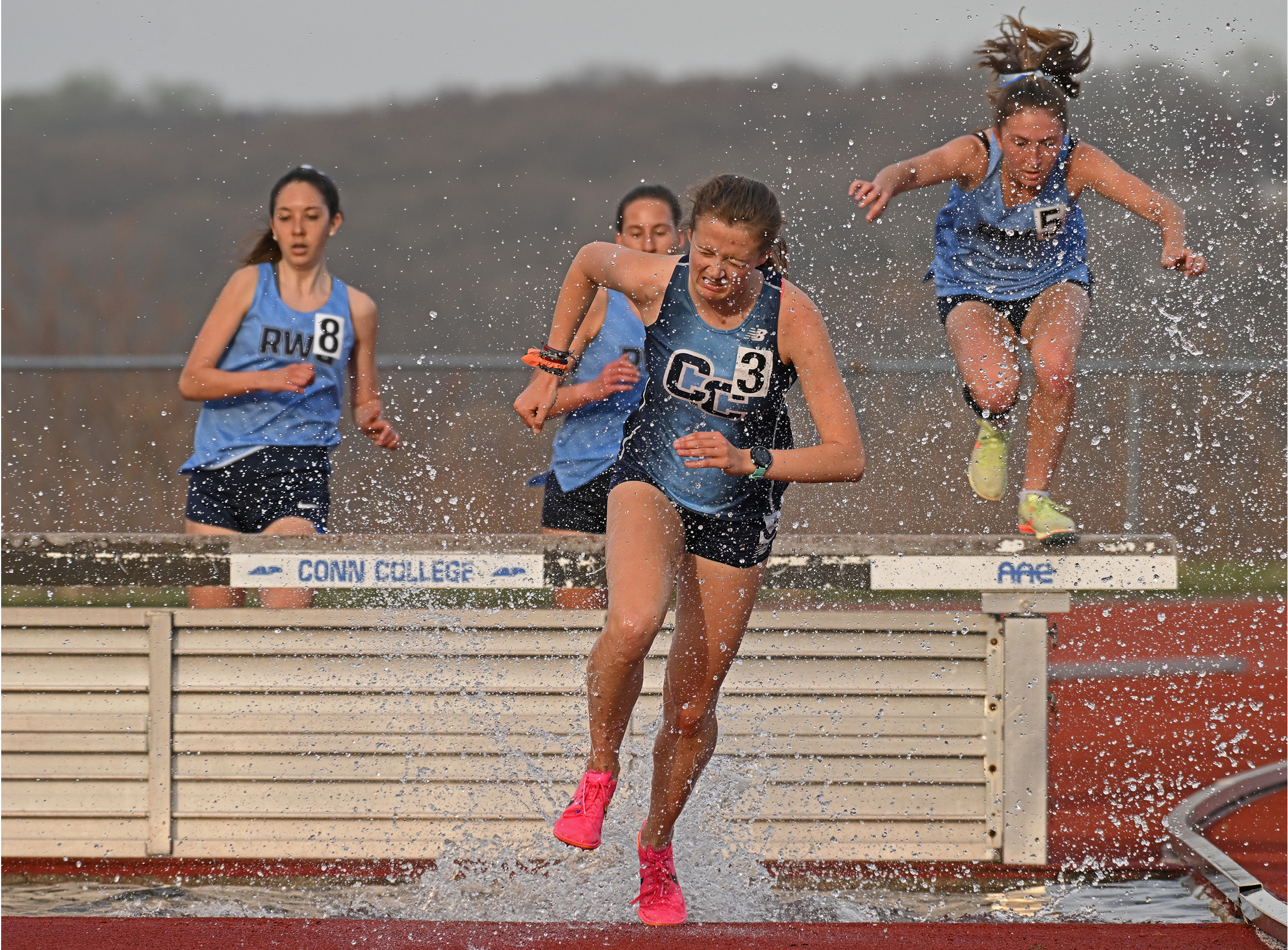 Hurdlers land in the water at a track meet in April.