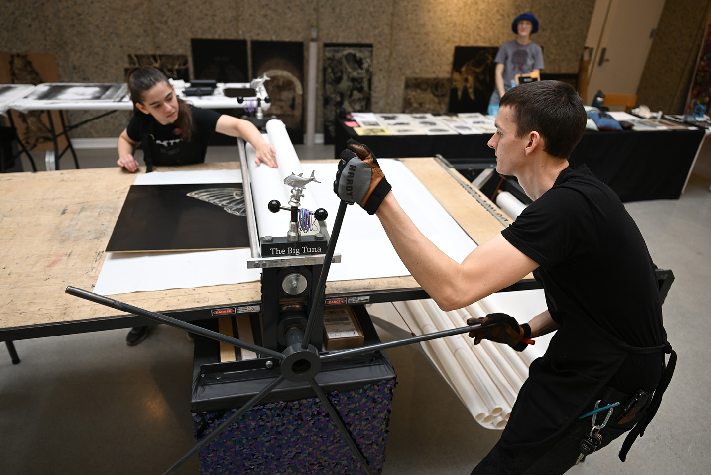 Students using a printing press in a printmaking class