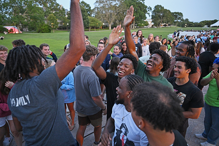 Students high five before an evening Arrival Day event on Tempel Green.