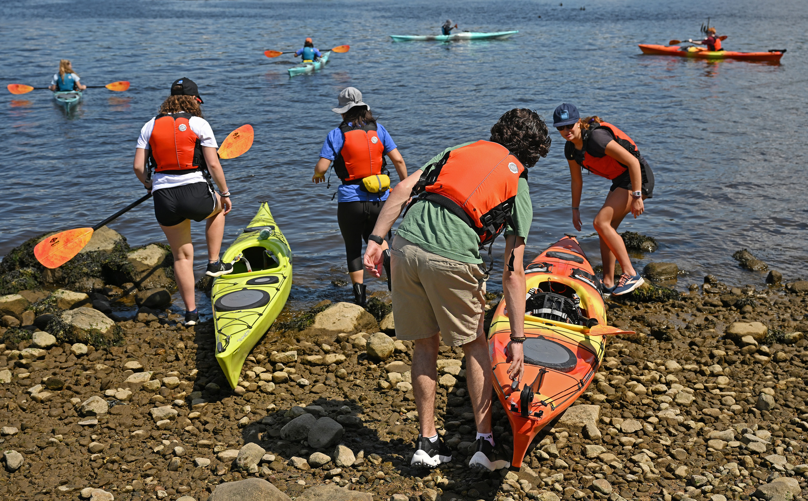 Students launch kayaks into the river at the Waterfront.