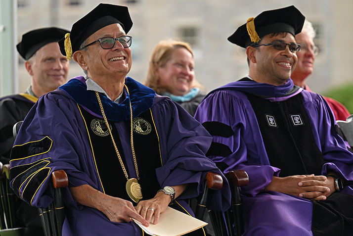 Interim President Les Wong and Board of Trustees Chair Debo Adegbile smile as Professor Nina Martin gives the keynote address at Convocation