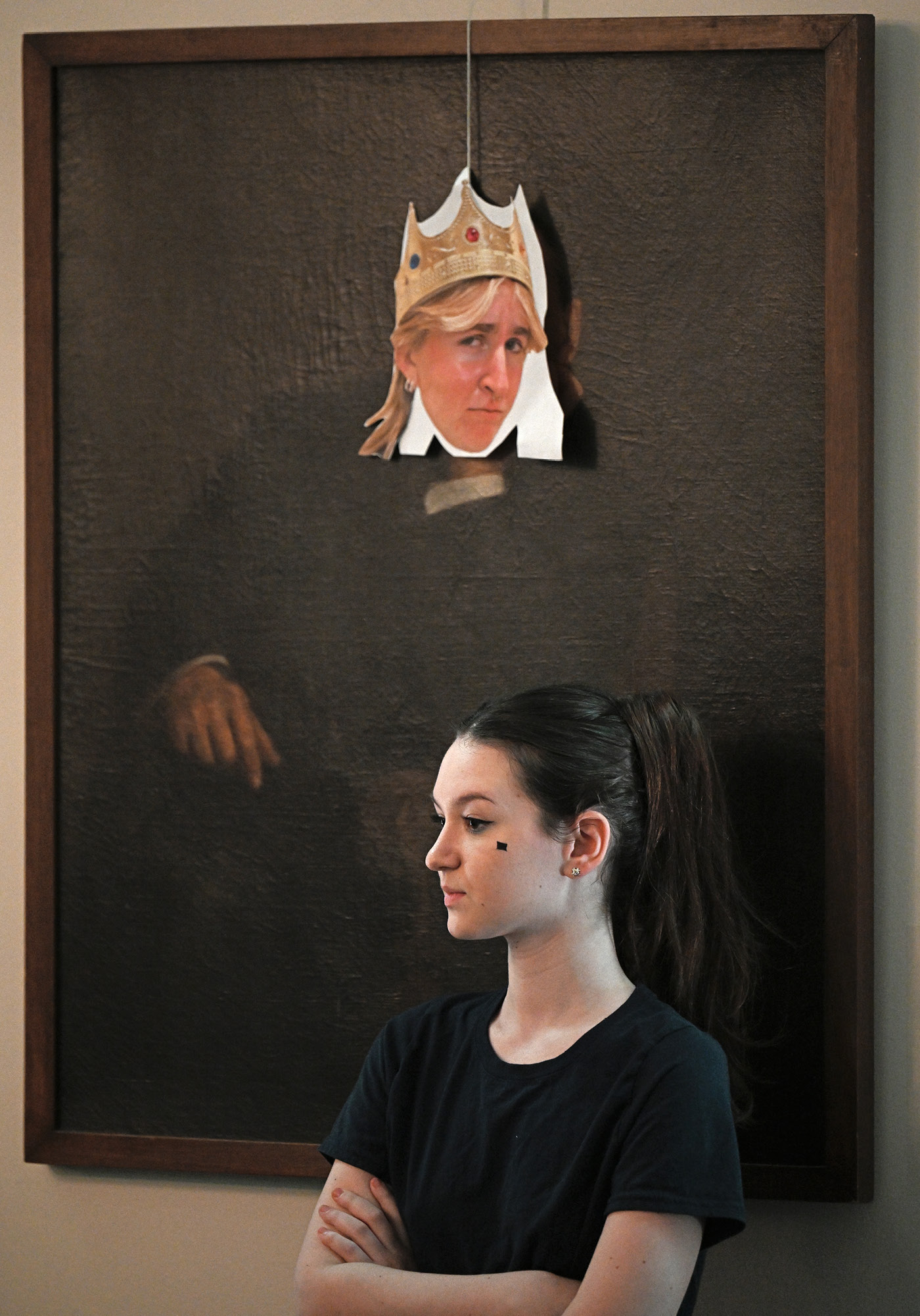 Student poses under a cutout character during the Wig & Candle production of Pippin.