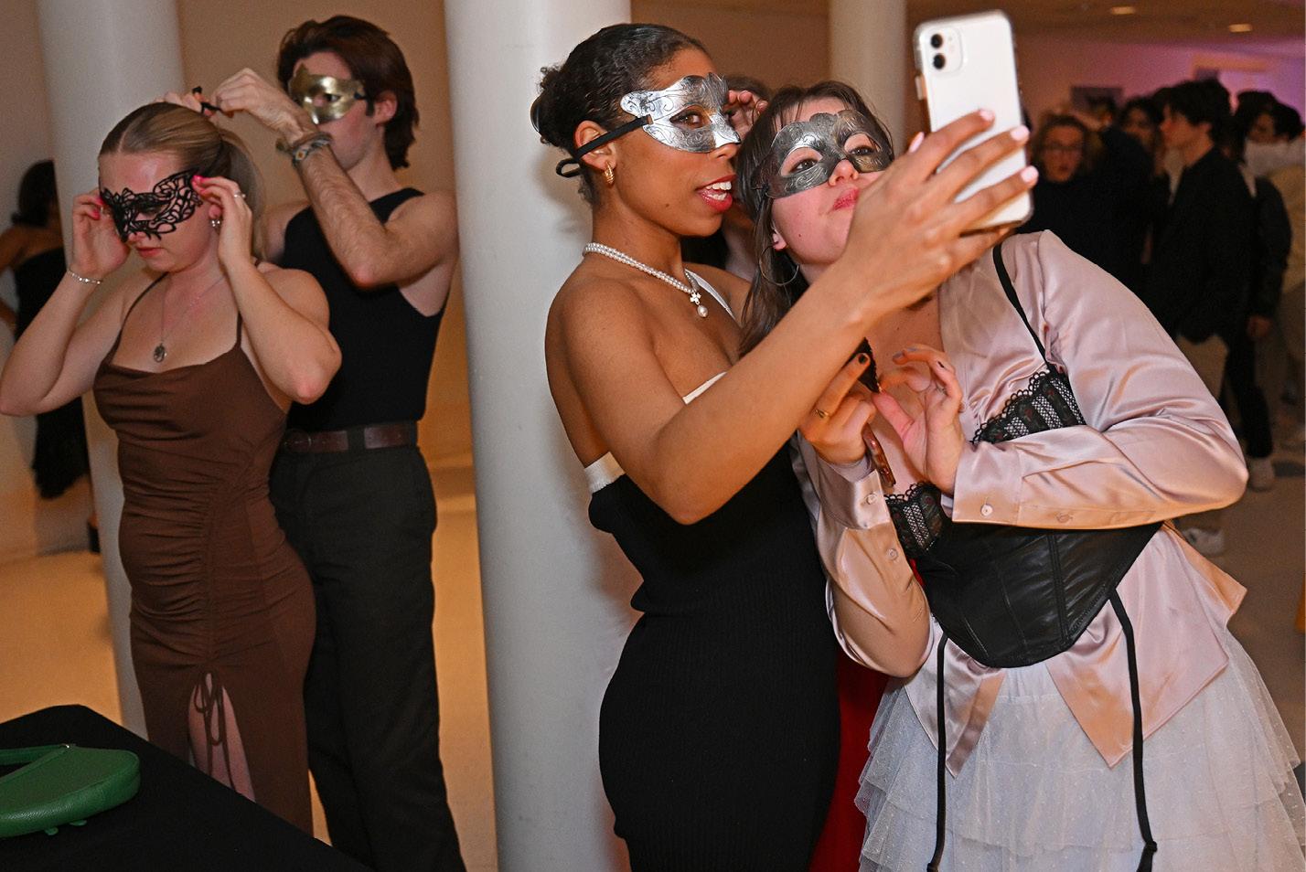 Students take selfies at the winter formal masquerade ball sponsored by the Student Activities Council in the 1962 Room.