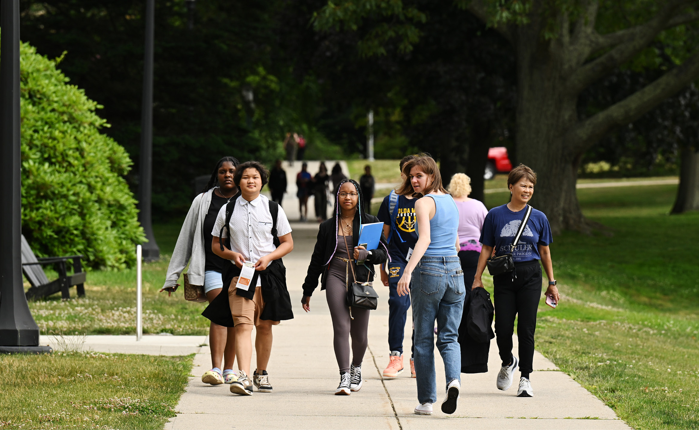 A tour guide leads a group of prospective students and families near Tempel Green.