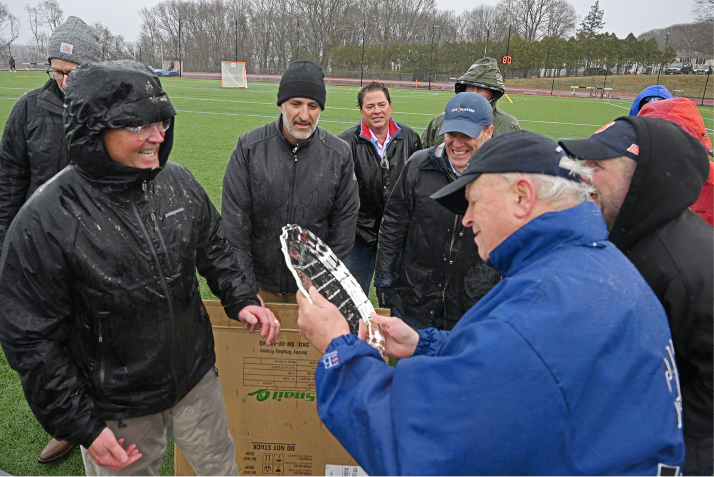 Former Connecticut College men’s lacrosse head coach Fran Shields, right, accepts a commemorative platter from members of his 1993 team .