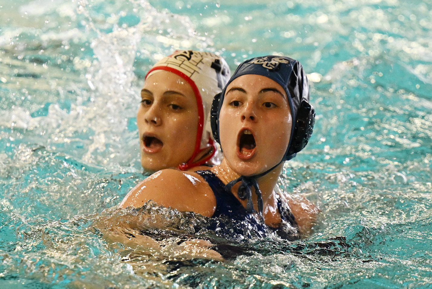 Women's water polo players anticipate the shot.