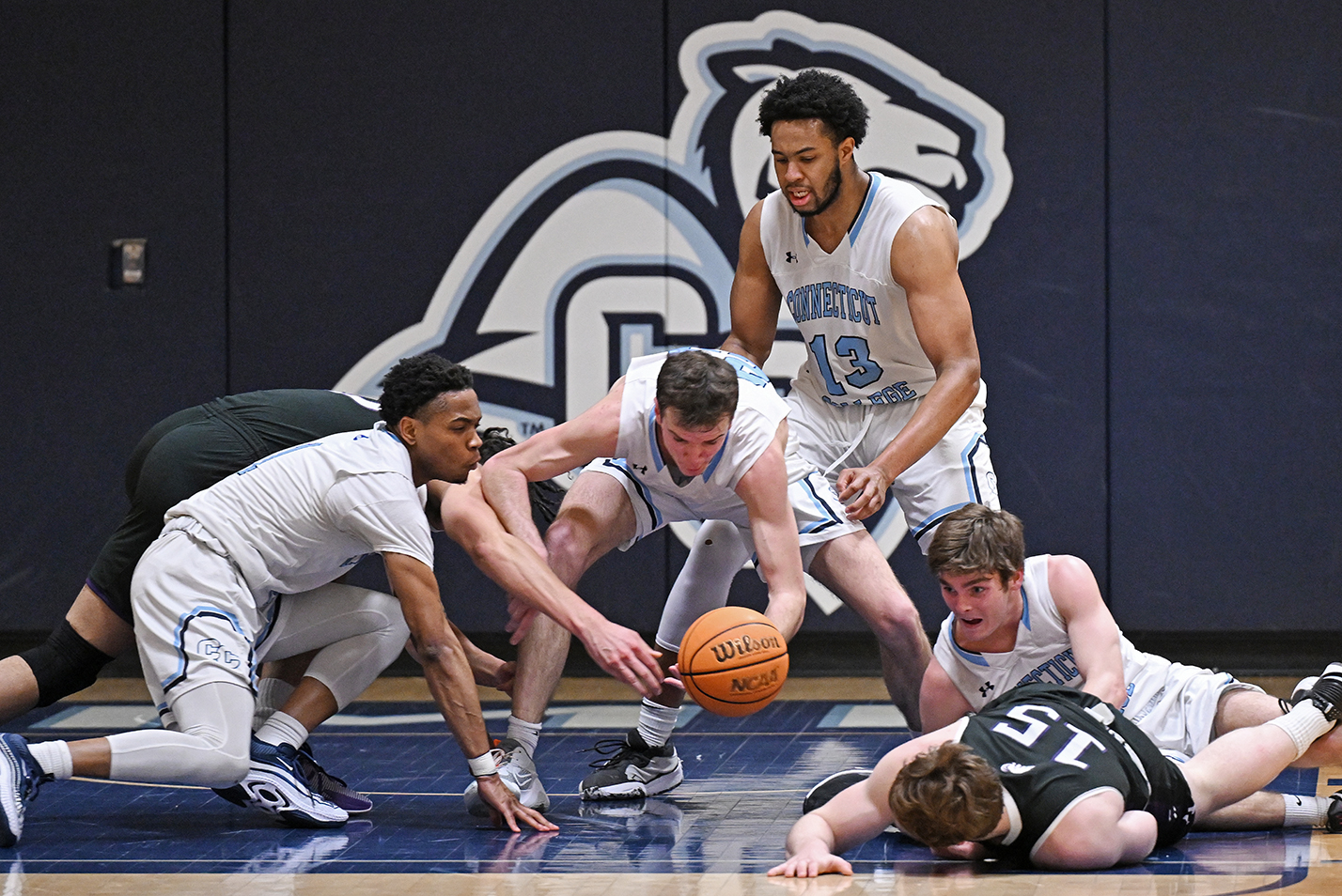 Basketball players scramble on floor for loose ball