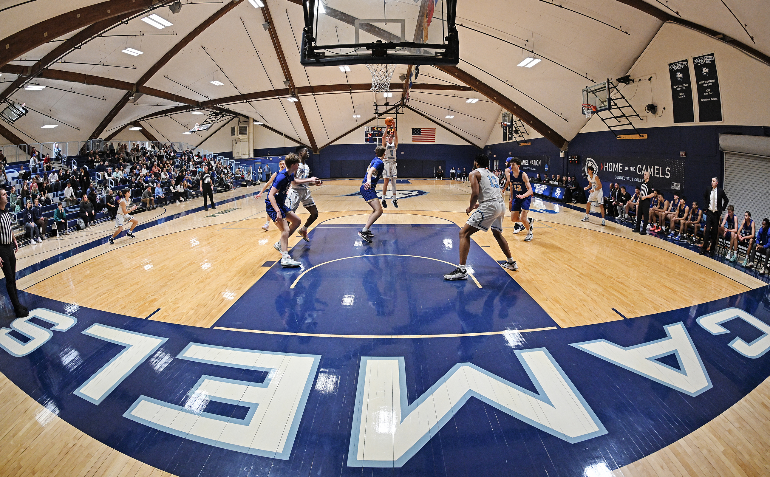 wide-angle view of basketball player taking a long jump shot